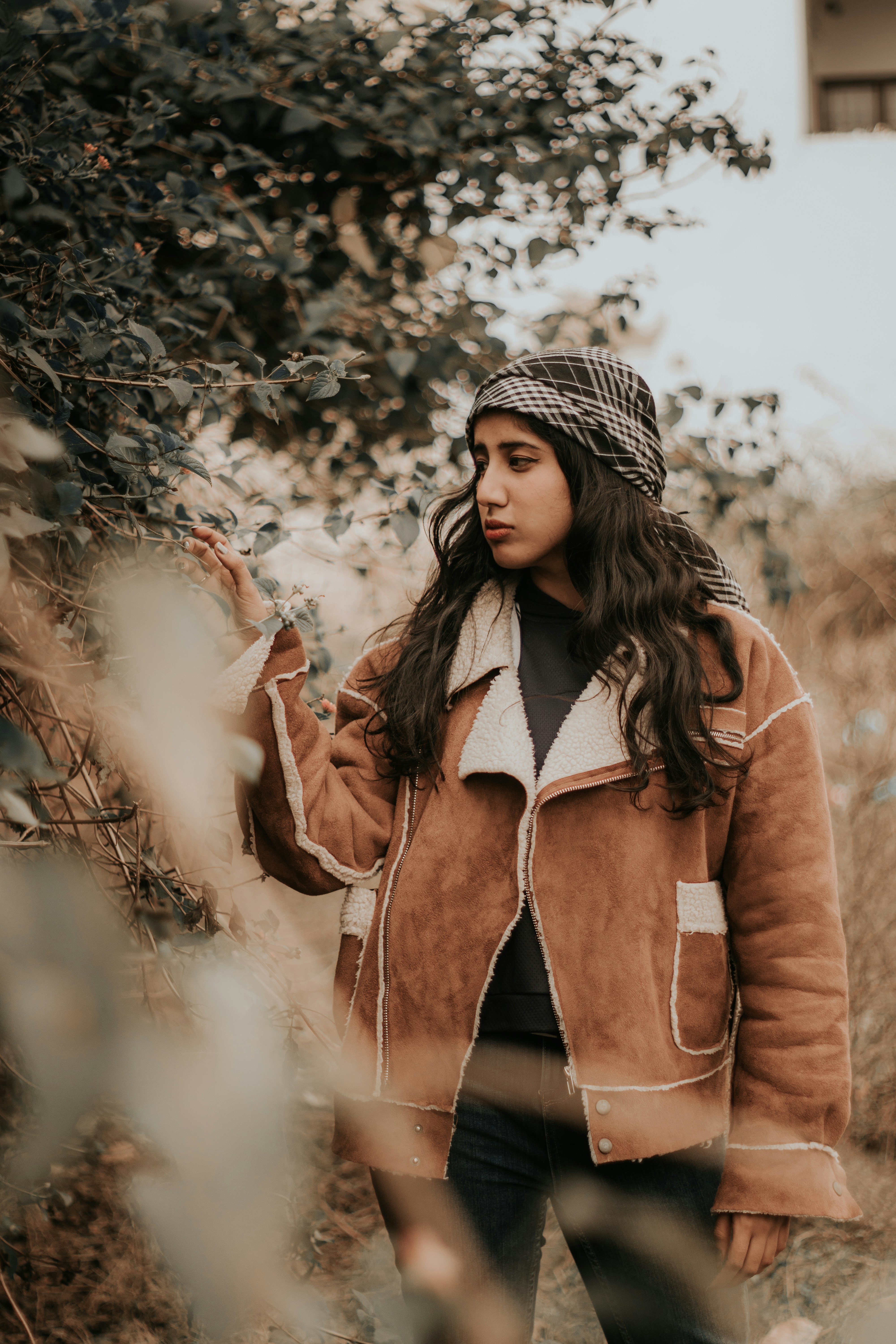 woman in brown coat standing near white smoke